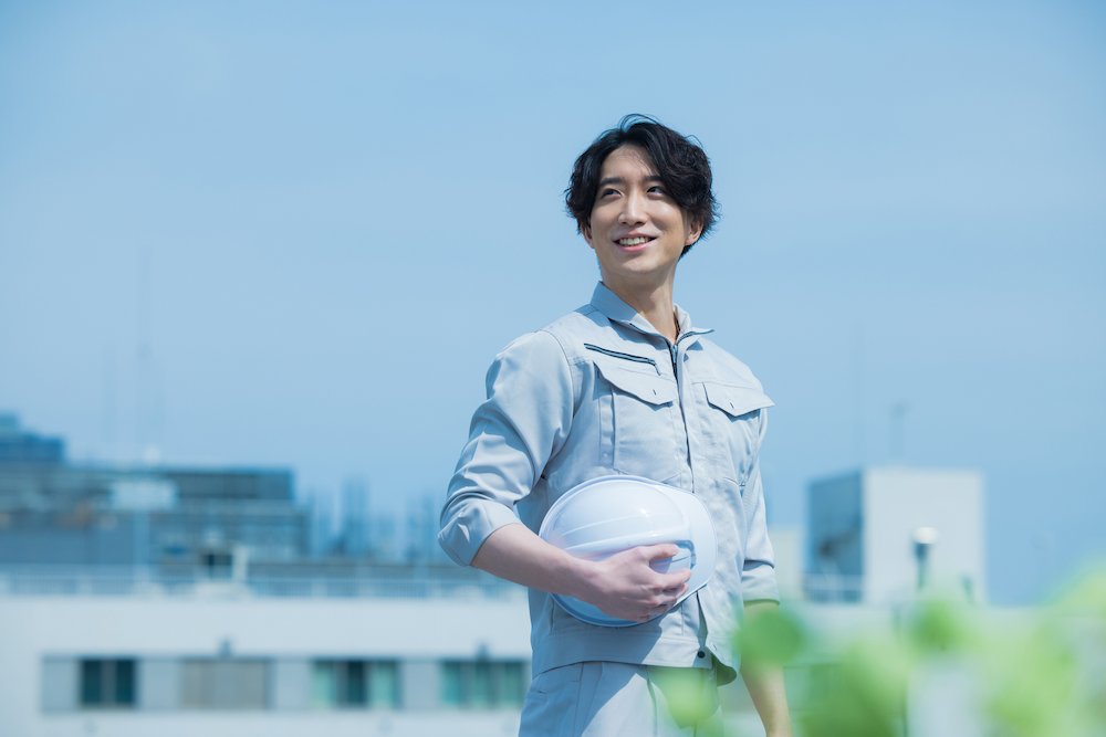 爽やかに微笑む作業服を着た人